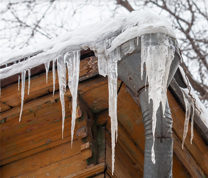 icicles hanging off of the gutters and pipes of a house