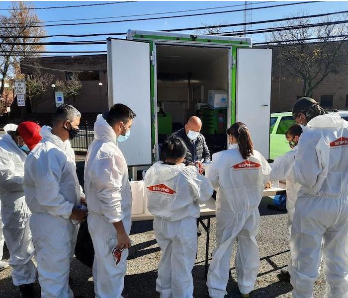 SERVPRO technicians in PPE around a table
