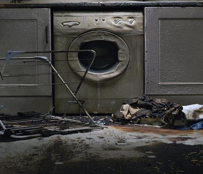 damage washing machine with clothes on the floor